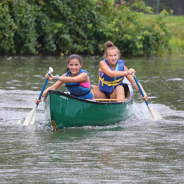 Two 7th grade girls canoeing at BT Camps in Baltimore County.