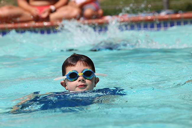 Young boy swimming in the pool at Nursery Camp; one of the many summer camp programs at BT Camps.