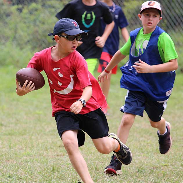 Two boys playing football at Sports Camp.