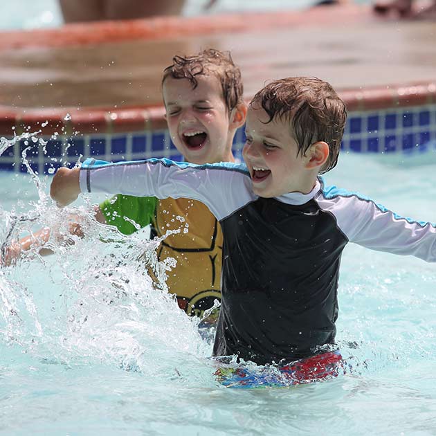 Kindercamp Two boys swimming in the pool at a summer day camp in Baltimore County.